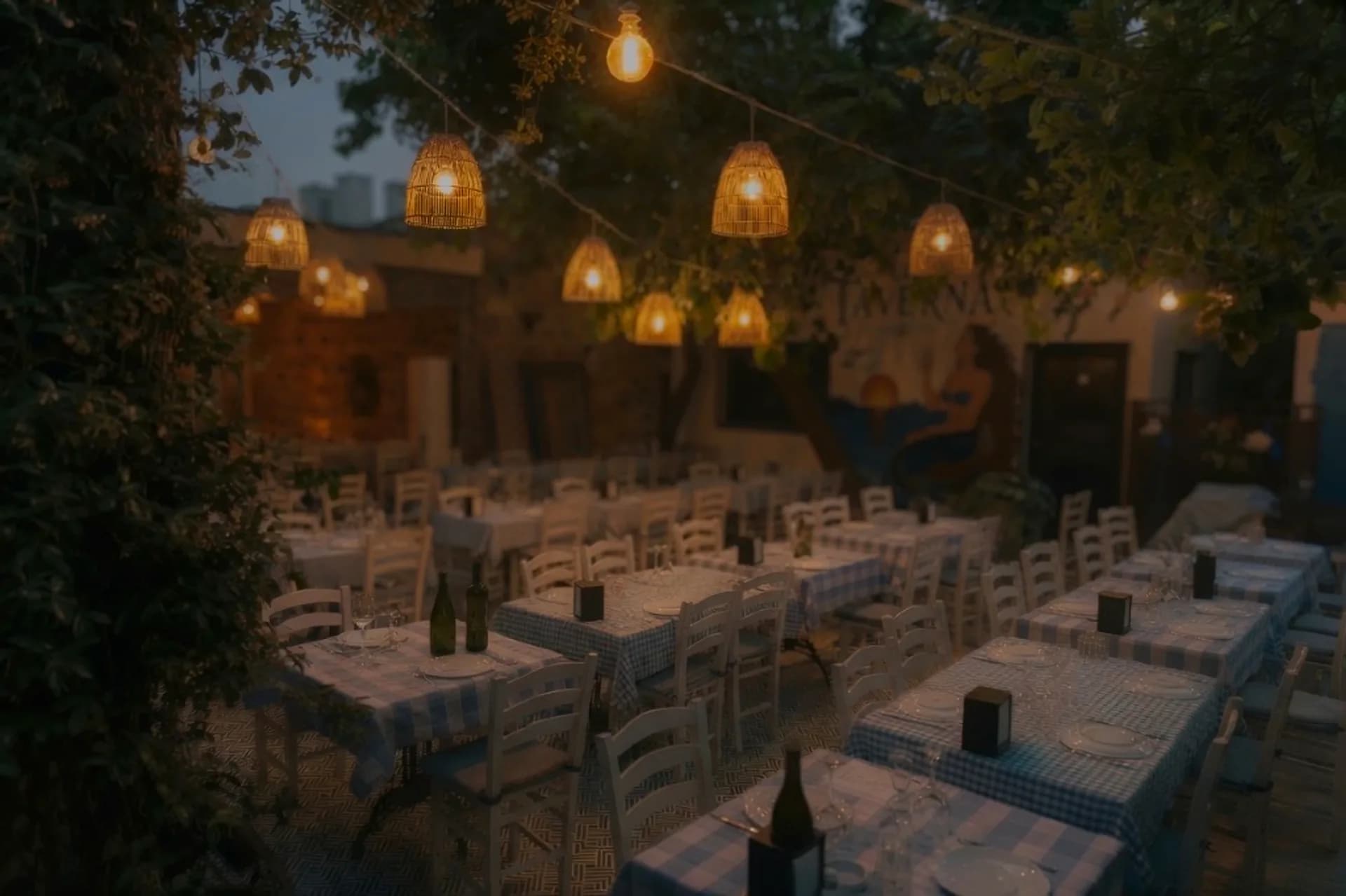 La Taverna Cunda gece avlusunda fener ışıkları ve meze sofrası